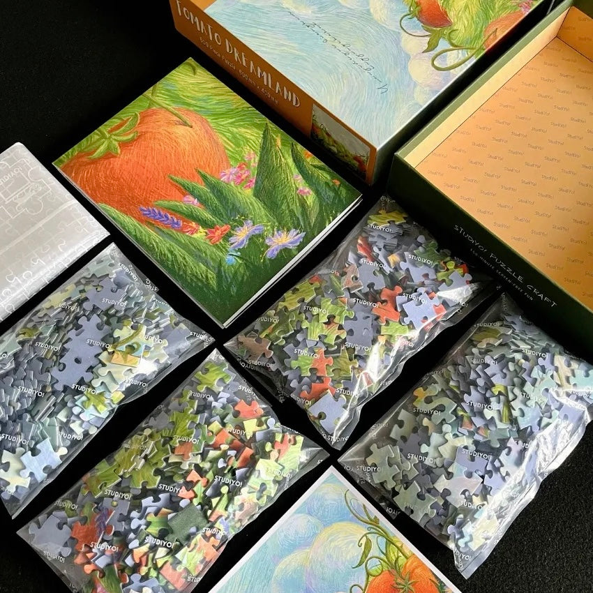Tomato Dreamland is a 600-piece puzzle from StudiYo!. Art by Yuan Ji. This puzzle takes you into a whimsical tomato field, where a girl and her little companions wander through lush green meadows surrounded by bright tomatoes and delicate wildflowers.